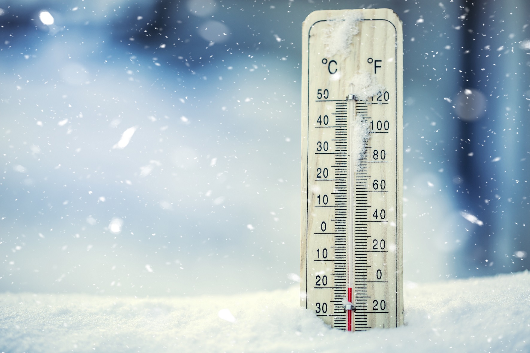 Thermometer on snow shows low temperatures under zero. Low temperatures in degrees Celsius and fahrenheit. Cold winter weather twenty under zero